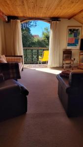 ein Wohnzimmer mit zwei Sofas und einem großen Fenster in der Unterkunft Tranquility and Nature - 8 minutes from downtown Capivari in Campos do Jordão