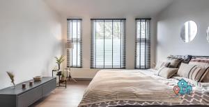 - une chambre avec un grand lit et des fenêtres dans l'établissement De Jordaan Luxury, à Amsterdam