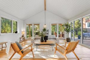 a living room with a couch and a table and chairs at Architect-Designed Holiday Home Close To The Water in Marielyst