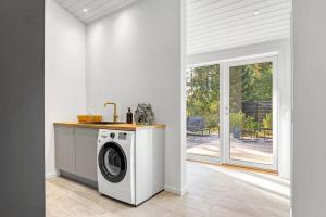 a kitchen with a washer and dryer in a room at Architect-Designed Holiday Home Close To The Water in Marielyst