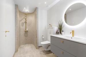 a bathroom with a shower and a toilet and a sink at Architect-Designed Holiday Home Close To The Water in Marielyst +29 photos