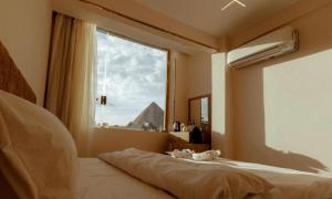 Un dormitorio con una cama con una ventana grande. en Honey Pyramids Hotel, en El Cairo 32 fotos más