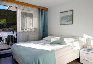 a bedroom with a bed and a window with a table at Garden Apartments Janša in Radovljica