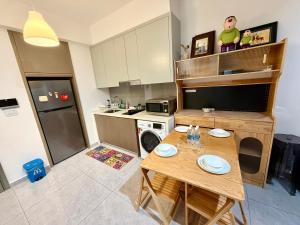 a small kitchen with a wooden table and a kitchen with a refrigerator at Agile bukit bintang trx by klcc sky view in Kuala Lumpur