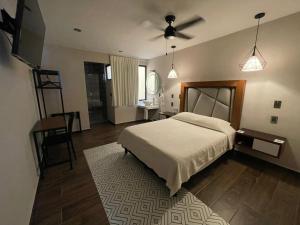 ein Schlafzimmer mit einem Bett, einem Tisch und einem Spiegel in der Unterkunft Hotel Casa María Tamasopo in Tamasopo