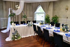 a room with long tables and chairs with flowers at Hotel Piast in Opole