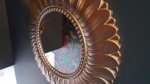 a gold mirror with a reflection of a vase in it at Clisham Bed and Breakfast in Lochcarron +10 photos