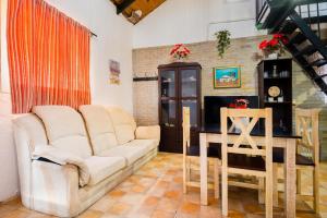ein Wohnzimmer mit Sofa und Tisch in der Unterkunft El Paraíso Del Olivar in Bollullos de la Mitación