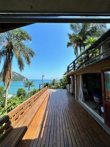 eine Holzterrasse mit Meerblick in der Unterkunft Casa 4 suítes - Vista para Barra do Sahy in São Sebastião