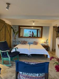 ein Schlafzimmer mit zwei Betten und einem Fenster mit zwei Personen in der Unterkunft Casa 4 suítes - Vista para Barra do Sahy in São Sebastião