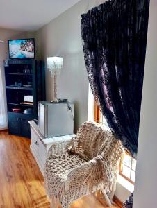 a living room with a chair and a tv at Gemma in Mossel Bay