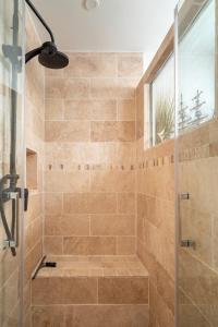 une salle de bain avec une douche avec une porte vitrée dans l'établissement Lou Cabanot 640 portes du Bassin, à Le Barp