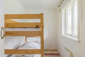 a bunk bed in a small room with a window at Cottage With Private Lake And Sauna Near Näshult in Åseda