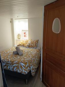 Un dormitorio con una cama y una puerta de madera. en Escapade cosy à Voglans avec terrasse au calme, en Voglans