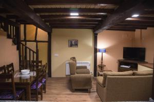 ein Wohnzimmer mit Tisch und Stühlen und einem Fernseher in der Unterkunft Casa Rural LA REGADERA II in Candelario