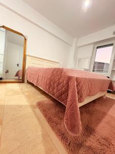 a bedroom with a bed with a pink blanket on it at Ultracentral 1 Craiova in Craiova