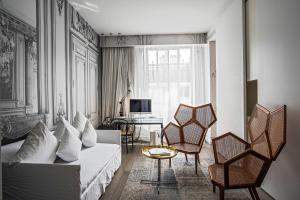パリにあるラ メゾン シャンゼリゼの白いソファと椅子のあるリビングルーム