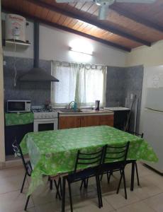 una cocina con mesa y mantel verde. en Departamentos Susana & Aldo, en Valle Hermoso