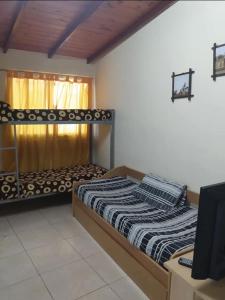 Un dormitorio con dos camas y un televisor. en Departamentos Susana & Aldo, en Valle Hermoso