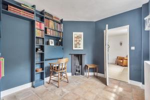 a living room with blue walls and a fireplace at The Long Cottage with attic in Flitcham