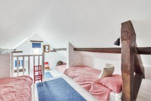 a attic bedroom with two beds and a ladder at The Long Cottage with attic in Flitcham