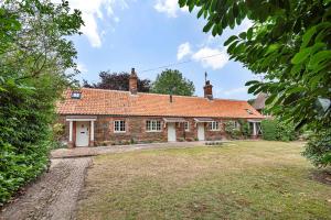 an old brick house with a yard in front of it at The Long Cottage with attic in Flitcham