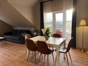 a living room with a table and chairs and a couch at Guesthouse Hvammur by the Harbour in Höfn