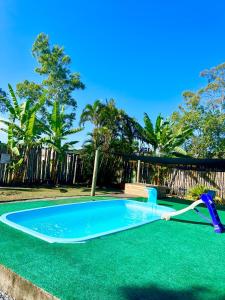 a swimming pool with a slide in the middle at Recanto Monte Trigo Quartos in São Francisco do Sul