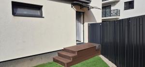 eine Holzbank auf der Seite eines Hauses in der Unterkunft C&C apartamente in Târgu Mureș