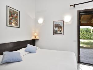 een witte slaapkamer met een bed en een raam bij Villa Rosamar in Monte Nai
