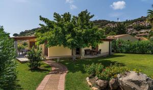 een tuin met een huis en een boom bij Villa Rosamar in Monte Nai