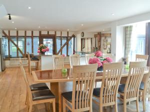 a kitchen and dining room with a wooden table and chairs at Burfields Barn in Rickinghall