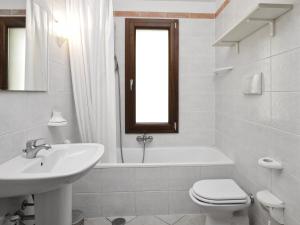 een badkamer met een wastafel, een toilet en een ligbad bij Villa Rosamar in Monte Nai +25 foto's