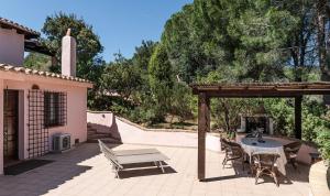 a patio with a table and chairs and a pergola at Villa Fiori 4 in Is Molas 