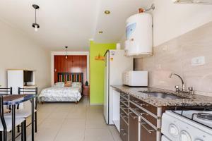 a kitchen with a sink and a room with a bed at Monoambiente-Wifi 100mb-TvCable-Centro San Rafael Segovia in San Rafael