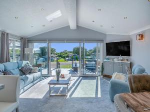 a living room with blue couches and a tv at 36 At The Sanctuary - Uk50278 in Carnguwch