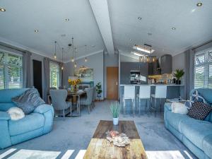 a living room with two blue couches and a kitchen at 36 At The Sanctuary - Uk50278 in Carnguwch