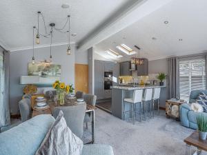 a living room with a blue couch and a kitchen at 36 At The Sanctuary - Uk50278 in Carnguwch