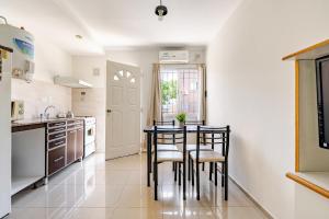 a kitchen with a table and chairs in a room at Monoambiente-Wifi 100mb-TvCable-Centro San Rafael Segovia in San Rafael