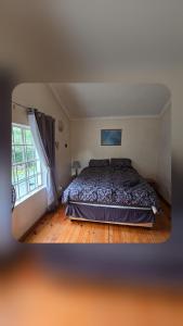 a bedroom with a bed and a window at Bunkers Accomodation in Underberg