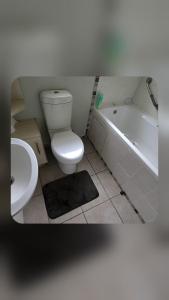 a bathroom with a toilet and a tub and a sink at Bunkers Accomodation in Underberg