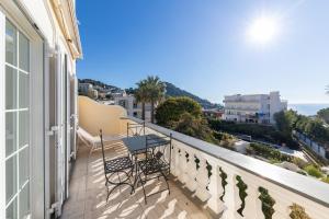 卡普里Hotel Residence Villa Igea Capri的带椅子的阳台，可欣赏海景