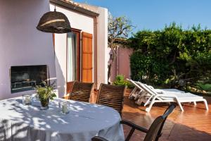 a patio with a table and chairs and a fireplace at Villa Roberta in Monte Nai