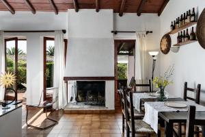 a dining room with a fireplace and a table and chairs at Villa Roberta in Monte Nai