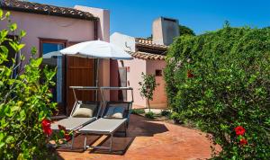 a patio with a chair and an umbrella at Villa Roberta in Monte Nai +19 photos