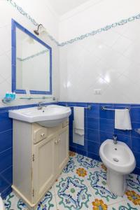 卡普里Hotel Residence Villa Igea Capri的带水槽和马桶的蓝白色浴室