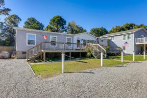 une maison avec une terrasse drapeau américain dans l'établissement Coastal Cozy - Newport Home with Private Hot Tub, à Broad Creek