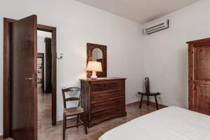 een slaapkamer met een ladekast, een spiegel en een stoel bij Villa Palme in Monte Nai