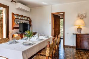 een eetkamer met een lange tafel en stoelen bij Villa Palme in Monte Nai +18 foto's