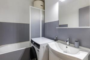 ein Badezimmer mit Waschbecken und Waschmaschine in der Unterkunft Kamélia - 10min des pistes in Xonrupt-Longemer